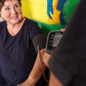 Ein Trainer überprüft die Vitalwerte bei einer Frau im modernen Fitness- und Physiotherapie-Bereich in Essen - gezieltes Muskeltraining zur Prävention und Gesundheitsförderung.